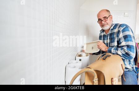 Klempner oder Klempner repariert Toilettenzisterne im Badezimmer Stockfoto