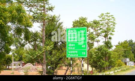 07. Juli 2021- Reengus, Sikar, Indien. Post-Schild, um über einige Städte Entfernung mit grünem Hintergrund zu informieren. Indische Straße und Transport concep Stockfoto