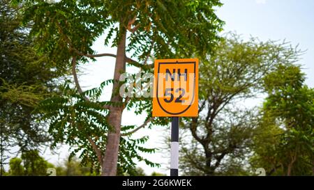 Attraktives Schild mit geschriebenem Text der großen NH 52 Straße und gelbem Hintergrund. Transportkonzept. Stockfoto