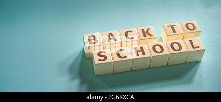 Holzspielzeugblöcke bilden die Worte „Back to School“. Die Schulen werden nach den Sommerferien wieder eröffnet. Stockfoto