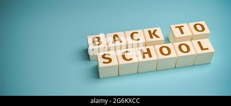 Holzspielzeugblöcke bilden die Worte „Back to School“. Die Schulen werden nach den Sommerferien wieder eröffnet. Stockfoto