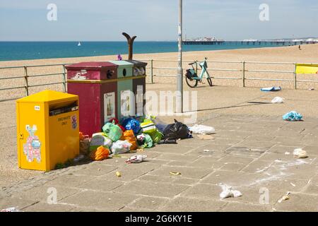 Überlaufene Mülltonnen mit Möwenschäden an den Tüten an der Strandpromenade von Brighton, East Sussex, England Stockfoto