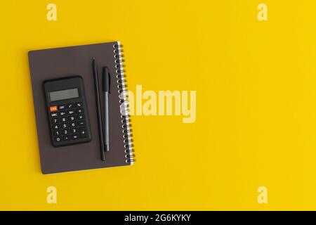 Taschenrechner, Notizbuch und Stift auf gelbem Hintergrund. Draufsicht. Flach liegend. Zurück zum Schulkonzept. Stockfoto