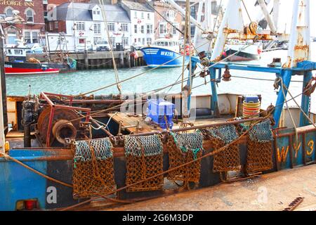 Muschel oder Jakobsmuscheln ziehen Netze auf einem Fischerboot im Hafen von Weymouth in Dorset, England. Stockfoto