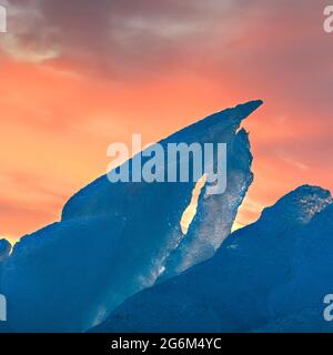 Eisberg mit lebhaftem arktischem Sonnenaufgangslicht. Spitzbergen, Spitzbergen, Norwegen, Acrytic Stockfoto