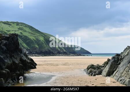 Eine wunderschöne Aussicht auf eine Küstenwanderung in North Devon, mit detailliertem Fokus von einer Felsformation auf dem Putsborough Sands an einem klassischen britischen Sommertag. Stockfoto