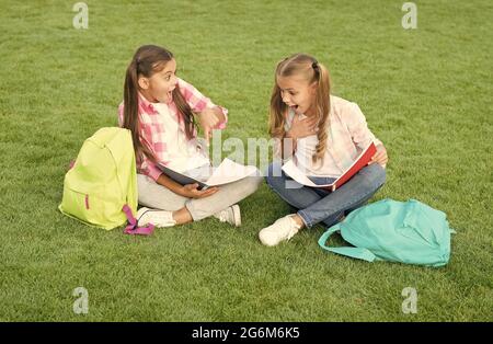 Kleine Kinder Mädchen lesen Bücher sitzen auf Gras, Wissen Tag Konzept Stockfoto