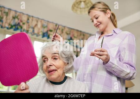 Weibliche Mobile Friseur Schneiden Senior Womans Haar zu Hause Stockfoto