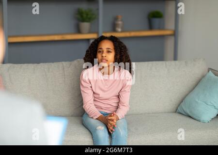 Psychologin, die mit verärgerten afroamerikanischen Mädchen im Büro arbeitet, traurige Teenager-Patientin, die über ihre Gefühle spricht Stockfoto