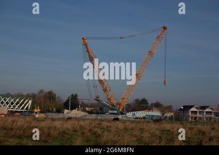 Sehr großer gelber Mobilkran mit V-förmigem Gestänge gegen einen blauen Himmel Cambridge England Stockfoto