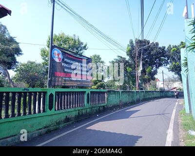 Editorial Photo, 04 July 2021, Indonesien, Ost-Jakarta, Gate Datuk Merah oder Merrah, mit Transparent, dass der Friedhof aufgrund der Covid-19 Pandemie geschlossen wurde Stockfoto