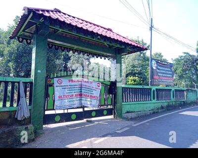 Editorial Photo, 04 July 2021, Indonesien, Ost-Jakarta, Gate Datuk Merah oder Merrah, mit Transparent, dass der Friedhof aufgrund der Covid-19 Pandemie geschlossen wurde Stockfoto