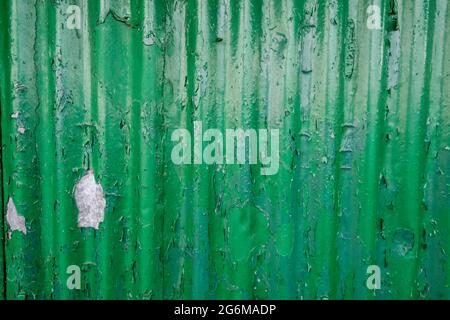 Grün abblätternder Lack auf Wellstahlverkleidung Stockfoto