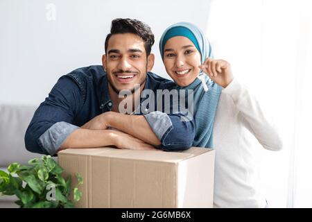 Schlüsselanhänger in lächelnden muslimischen Paarhände, bewegendes Konzept Stockfoto