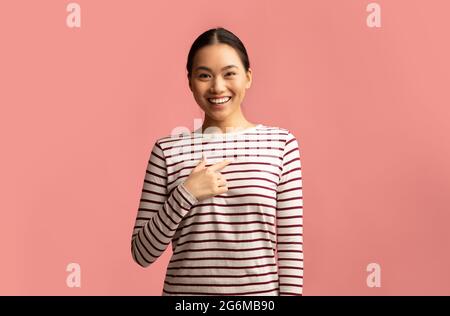 Wählen Sie Mich. Positive Junge Asiatische Frau Zeigt Finger Auf Sich Selbst. Stockfoto
