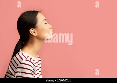 Seitenansicht Porträt Einer Jungen Asiatischen Frau, Die Air Kiss Sendet Stockfoto