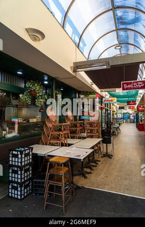 Geschlossene Cafés mit gestapelten Stühlen, in einer Arkade in Balmain, Sydney, Australien während einer Pandemie-Sperre Stockfoto