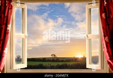 Atemberaubender Blick vom offenen Fenster auf die ländliche Landschaft bei Sonnenaufgang im Sommer. Stockfoto