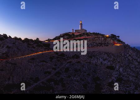 Lighttrails von Autos am Cap the Formentor während der blauen Stunde. Stockfoto