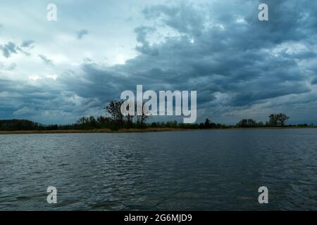 Unruhige Abendwolken über einem ruhigen See Stockfoto