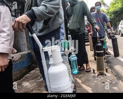 Jakarta, Indonesien. Juli 2021. Verwandte von Covid-19-Patienten warten vor einem Sauerstofffüllzentrum, um ihre leeren Flaschen aufzufüllen, da die Nachfrage nach dem Gas aufgrund der Spitzen bei Coronavirus-Fällen steigt. Der Anstieg der schrecklichen Coronavirus-Fälle hat in Indonesien zu Sauerstoffmangel geführt, wie der Sauerstofflieferant am Dienstag mitteilte. (Foto von Agung Fatma Putra/SOPA Images/Sipa USA) Quelle: SIPA USA/Alamy Live News Stockfoto