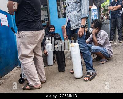 Jakarta, Indonesien. Juli 2021. Verwandte von Covid-19-Patienten warten vor einem Sauerstofffüllzentrum, um ihre leeren Flaschen aufzufüllen, da die Nachfrage nach dem Gas aufgrund der Spitzen bei Coronavirus-Fällen steigt. Der Anstieg der schrecklichen Coronavirus-Fälle hat in Indonesien zu Sauerstoffmangel geführt, wie der Sauerstofflieferant am Dienstag mitteilte. Kredit: SOPA Images Limited/Alamy Live Nachrichten Stockfoto