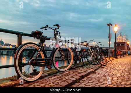 Abends Blick auf geparkte Fahrräder am niederländischen Fluss Maas in der Stadt Maastricht Stockfoto