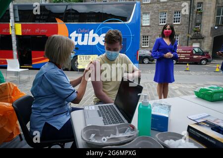 Schottlands stellvertretende Chief Medical Officer Dr. Nicola Steedman beobachtet, wie Krankenschwester Susan Pate Matt Donaghey einen Impfstoß verabreicht, während sie einen Impfbus besucht, der vom Scottish Ambulance Service und NHS Lothian auf dem Grassmarket in Edinburgh betrieben wird. Bilddatum: Mittwoch, 7. Juli 2021. Stockfoto