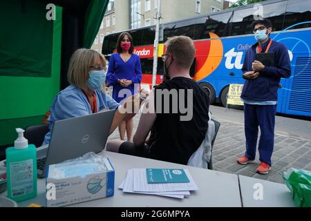 Schottlands stellvertretende Chief Medical Officer Dr. Nicola Steedman beobachtet, wie Krankenschwester Susan Pate Maurice Hickman während eines Besuchs in einem Impfbus des Scottish Ambulance Service und des NHS Lothian auf dem Grassmarket in Edinburgh einen Impfjab verabreicht. Bilddatum: Mittwoch, 7. Juli 2021. Stockfoto