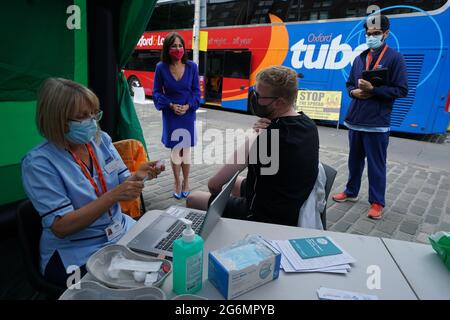 Schottlands stellvertretende Chief Medical Officer Dr. Nicola Steedman beobachtet, wie sich Krankenschwester Susan Pate während eines Besuchs in einem Impfbus des Scottish Ambulance Service und des NHS Lothian auf dem Grassmarket in Edinburgh auf die Verwaltung eines Impfjabs für Maurice Hickman vorbereitet. Bilddatum: Mittwoch, 7. Juli 2021. Stockfoto