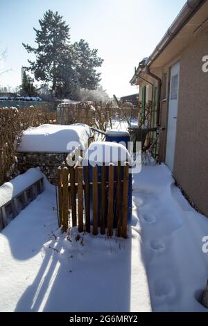 Im Winter ruht ein kleiner schneebedeckter Schottergarten Stockfoto