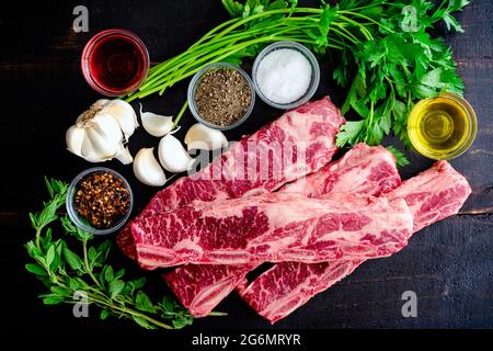 Argentinischer Stil gegrillte kurze Rippchen mit Chimichurri Zutaten: Flanken-Rindfleisch-Spareribs, Petersilie und andere Rohstoffe Stockfoto