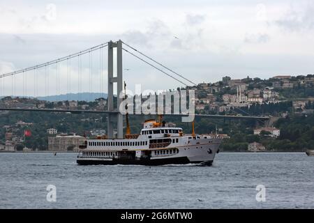 Die Fähre fährt durch die Bosporusstraße in Istanbıul, Türkei. Bogazici-Brücke im Hintergrund auch als Martyrs-Brücke vom 15. Juli bekannt. Stockfoto