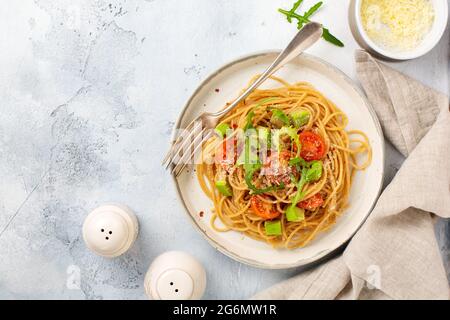 Spaghetti mit Pesto, Avocado und Tomaten auf rustikalem weißen Teller. Rohkost vegan Food-Konzept. Draufsicht. Stockfoto