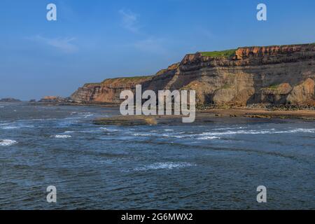 Die zerklüfteten Klippen und die Küste der klassischen, altmodischen britischen Küstenstadt Whitby in Yorkshire. Stockfoto