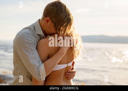 Fürsorgliches und schönes romantisches Paar in Umarmung am Strand Stockfoto