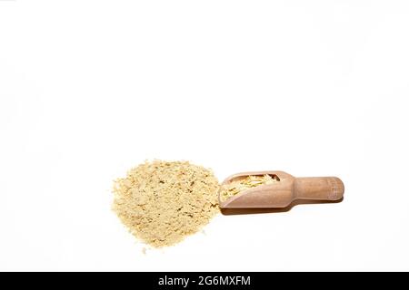 Nährhefeflocken in Holzlöffel isoliert auf weißem Hintergrund. Mit Platz für Text. Eine wichtige Quelle für Vitamin B12. Stockfoto