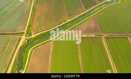 Landwirtschaftliches Grundstück mit grünen Pflanzen und landwirtschaftlichen Maschinen Ansicht von oben. Landschaft mit Ackerland. Stockfoto