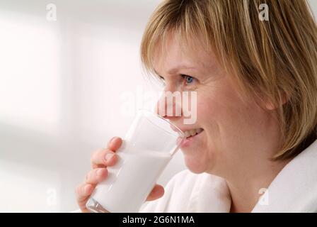 Weibliche Patientin, die Bariumsulfat-Suspension aus einem Glas trinkt Stockfoto