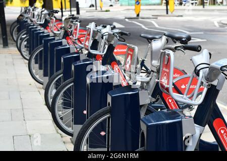 Eine Reihe von Santander-Fahrrädern auf einer Straße in London, Großbritannien Stockfoto