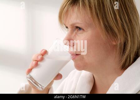 Weibliche Patientin, die Bariumsulfat-Suspension aus einem Glas trinkt Stockfoto