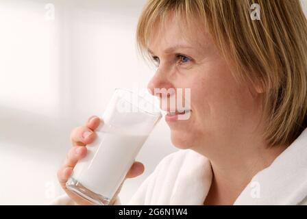 Weibliche Patientin, die Bariumsulfat-Suspension aus einem Glas trinkt Stockfoto