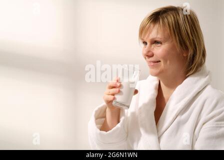 Weibliche Patientin, die Bariumsulfat-Suspension aus einem Glas trinkt Stockfoto