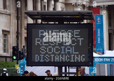 London, Großbritannien. Juli 2021. Bitte beachten Sie das Social Distancing-Schild am Trafalgar Square, wo die Spiele gezeigt werden, vor dem Halbfinale der Fußball-Europameisterschaft 2020 in England gegen Dänemark, das im Wembley Stadium gespielt wird. Kredit: SOPA Images Limited/Alamy Live Nachrichten Stockfoto