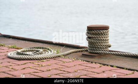 Poller und Anlegeseil von einem festfahrenden Schiff auf dem Mittellandkanal bei Magdeburg in Deutschland Stockfoto