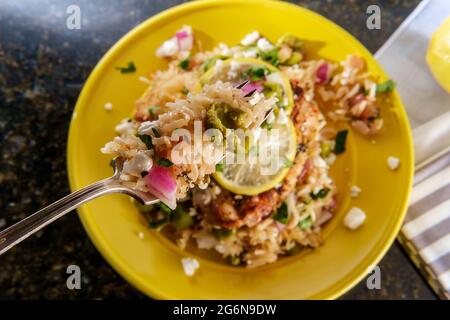 Griechische Haut-on Knochen-in knusprige Hähnchenschenkel mit Reis und castelvetrano Oliven mit Feta-Käse serviert Stockfoto