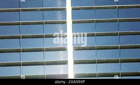 Sonnenkollektoren aus Drohnenantenne oben über Ansicht. Sonneneinstrahlung auf Photovoltaik-PV-Modulen im Hintergrund der Solaranlage. Stockfoto