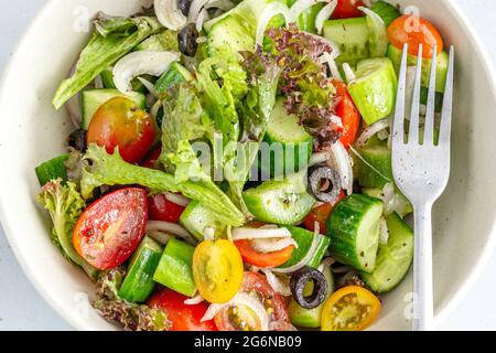 Gesunder Gurken- und Tomatensalat in einer Schüssel, oben nach unten, horizontales Nahaufnahme Foto Stockfoto