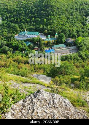 Blick aus der Höhe auf das Kloster Saharna, Moldawien. Idyllischer Ort mit der Kirche mitten im Wald am Klachtal Stockfoto