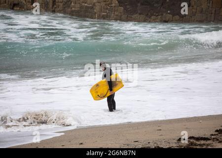 Portreath,Cornwall,7. Juli 2021,Trotz des grauen und trostlosen Wetters waren einige Leute bei Flut am Strand in Portreath, Cornwall. Surfer machten das Beste aus den großen Wellen, da das Wetter voraussichtlich 17C sonnige Intervalle mit einer leichten Brise später an diesem Abend sein wird.Quelle: Keith Larby/Alamy Live News Stockfoto